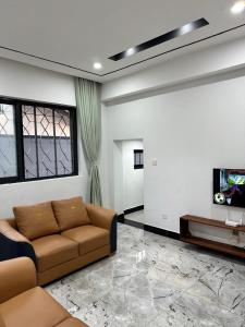 een woonkamer met een bank en een tv bij Masaki-2Bedroom-G03 in Dar es Salaam