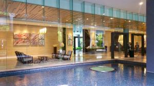 a swimming pool with chairs and a table in a building at M city Ampang Lake view in Kuala Lumpur