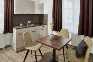 eine Küche mit einem Tisch, Stühlen und einem Waschbecken in der Unterkunft Gästehaus Stiftsstadt in Kempten