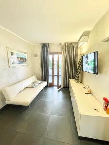 コゼンツァにあるSuite Roomsのソファとテレビのあるリビングルーム