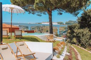 un patio con due sedie e un ombrellone e una piscina di The Lost Garden a Vila Nova de Gaia