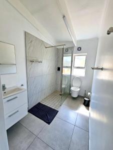 a bathroom with a shower and a sink and a toilet at Chakas Rock Chalet 45 in Ballito