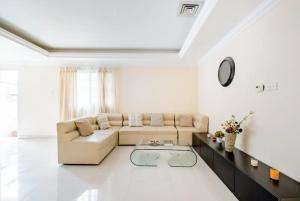 迪拜The Villa Jumeirah的带沙发和桌子的白色客厅