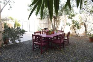 迪拜The Villa Jumeirah的一张带椅子和鲜花的木桌