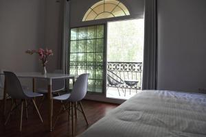 迪拜The Villa Jumeirah的一间卧室，配有一张床、一张桌子和几把椅子
