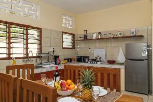 a kitchen with a table with a bowl of fruit on it at Germano Cottages Garden and Pool in Ukunda