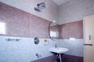 un bagno con lavandino e specchio di Nagadeep Residency a Mysore