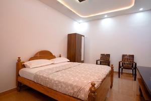 una camera da letto con un letto grande e due sedie di Nagadeep Residency a Mysore