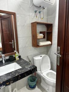 een badkamer met een toilet, een wastafel en een spiegel bij Masaki-2Bedroom-G03 in Dar es Salaam