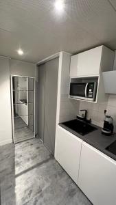 a kitchen with white cabinets and a microwave at Beau studio au cœur de Beaulieu-sur-mer in Beaulieu-sur-Mer