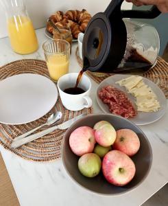une table avec un bol de pommes et une cafetière dans l'établissement Tunnelmallinen yksiö kaupungin läheisyydessä, à Lahti 4 autres photos