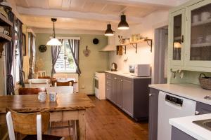 a kitchen with a wooden table and a dining room at Chalupa Tulipánka in Krásná Lípa