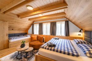 a bedroom with two beds and a chair at Roubenka Růženka - Říčky v Orlických horách in Wüstenei