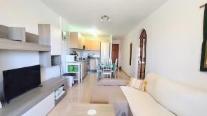 a living room with a couch and a tv at Residence La Perla in El Médano