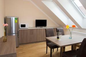 a living room with a table and a refrigerator at Limes Apartments in Prague