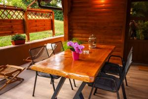 a wooden table with a vase of flowers on a patio at Luxury Love Cottage Spa- privatni jacuzzi &sauna , mir i privatnost in Velika Gorica