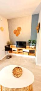 sala de estar con mesa blanca y TV en Évasion, Studio Cosy près de la Plage, en Saint-Nazaire