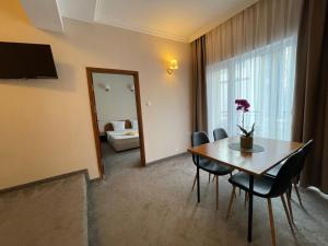 a dining room with a table and chairs and a bedroom at Alatoni Beach Hotel in Sozopol