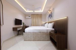 a hotel room with a bed and a desk at House 241 in Abuja