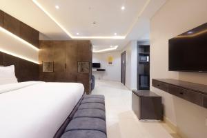 a bedroom with a large bed and a flat screen tv at House 241 in Abuja