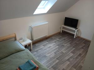 une chambre avec un lit et une télévision à écran plat dans l'établissement LivingRoom GmbH K72 Appartments in Salzgitter und Umgebung, à Baddeckenstedt 2 autres photos