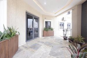 an empty lobby with potted plants and windows at House 241 in Abuja