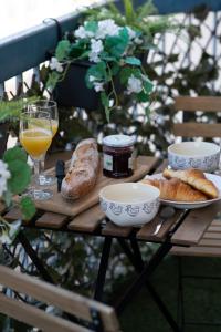 una mesa de madera con pan y un vaso de zumo de naranja. en HAPPY HOME COLMAR with PRIVATE PARKING, en Colmar
