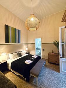 a bedroom with a large bed and a chandelier at Hotel Costa Rica in Buenos Aires