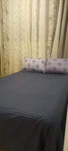 a bed with purple pillows in front of a curtain at 024 - Apto Studio Liberdade Sé 500'Metrô in Sao Paulo +59 photos