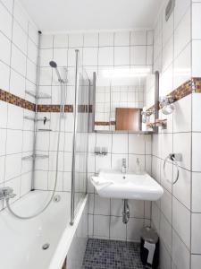 a white bathroom with a sink and a shower at Ferienwohnung Hexenstieg in Sankt Andreasberg