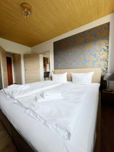 a large white bed in a room with a wall at Ferienwohnung Hexenstieg in Sankt Andreasberg +19 photos