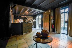 a living room with a table and a kitchen at Hôtel Au Comte de Mercy in Oupeye