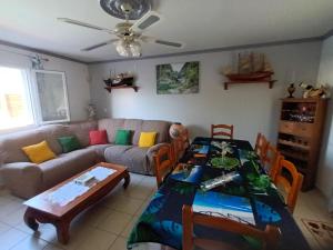 una sala de estar con un sofá y una mesa en La Villa Hibon, en Saint-Paul