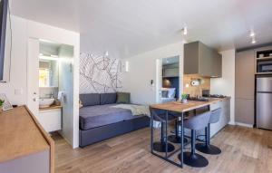 a room with a bed and a kitchen with a table at Batana Mobile Home in Banjole