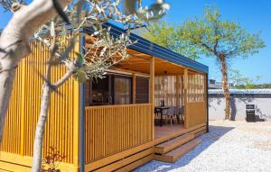 a yellow house with a table and a tree at Batana Mobile Home in Banjole
