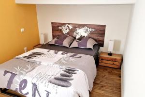 una camera da letto con un letto grande con testiera in legno di Maison, 4 à 6 pers, clim, parking privé, 2 chambres a Agen