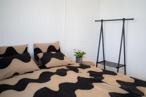 a bed with a black and white comforter and pillows at Villa Nurmenhelmi järven rannalla in Lempäälä