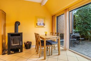 comedor con mesa y estufa de leña en Ferienhaus Kornblume, en Blankenburg