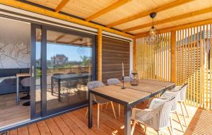 a dining room with a table and chairs on a deck at Ulika Mobile Home in Banjole