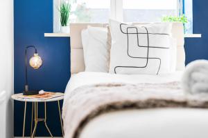1 dormitorio con paredes azules y 1 cama con almohadas blancas en Stylish Two Bedroom House - Parking - Garden 55H, en Birmingham