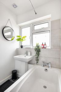 a white bathroom with a tub and a sink at Kent Haven - 3 bed house, Games room and Parking in Kent +31 photos