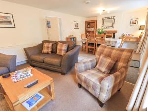 a living room with couches chairs and a table at Yew Tree Cottage Borrowdale in Rosthwaite