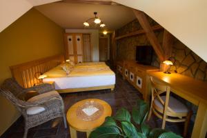 a bedroom with a bed and a tv and a table at Hotel a restaurace Palfrig in Stará Ves nad Ondřejnicí