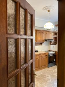 a kitchen with wooden cabinets and a door at Almeta Apartment 2 in Chios +13 photos