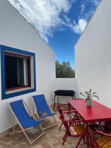 a patio with chairs and a table and a window at Casas Velhas - Casa da Taipa in Castro Verde