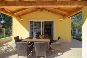 a wooden table and chairs on a patio at Ferienhaus mit Privatpool für 8 Personen ca 120 qm in Mugeba, Istrien Istrische Riviera in Mugeba