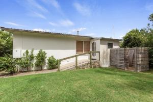 a white house with a fence and a yard at Skenes Creek Beach Retreat Free Wi-Fi Ocean views. in Skenes Creek