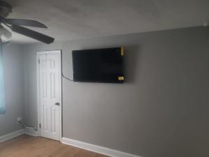 a flat screen tv on a wall in a room at Paradise Retreat by the Airport in Collingdale