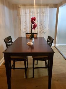 a table with chairs and a vase with a flower on it at Paradise Retreat by the Airport in Collingdale +11 photos