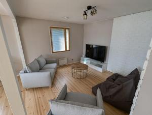 a living room with a couch and a tv at Villa Nurmenhelmi järven rannalla in Lempäälä